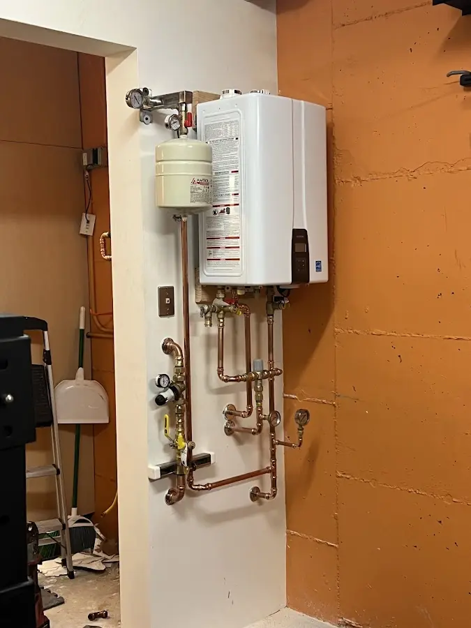 Plumbing technician inspecting water heater connections in Lilburn